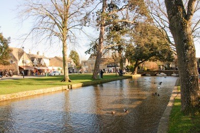 the quaint cotswold village of bourton on the water, gloucestershire, uk, with the brook running down the high street