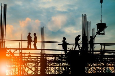 silhouette of engineer and construction team working at site over blurred background sunset pastel for industry background with light fair.