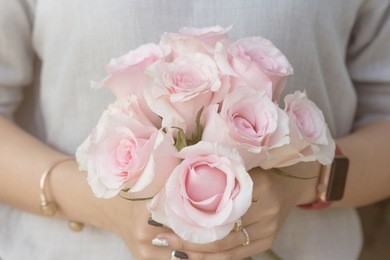 valentine’s day concept - lady’s hands holding roses flower bouquet. close up taken.