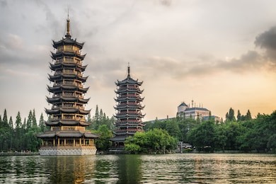 the sun and moon twin pagodas at sunset. amazing evening view of shanhu lake (fir lake) in downtown of guilin, china. guilin is a popular tourist destination of asia.