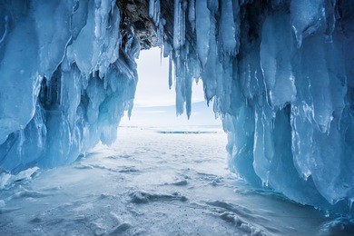 winter landscape, frozen ice cave with bright sunlight from way out at lake baikal in irkutsk, russia