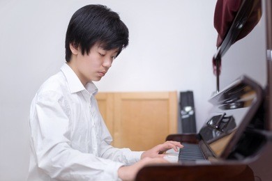 handsome young boy playing the piano