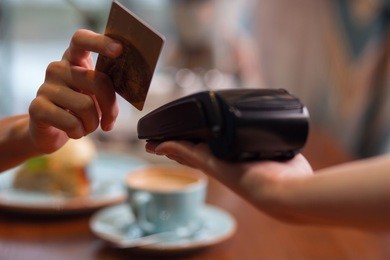 credit card usage. moment of payment with a credit card hold by female hand through terminal which carried by another hand