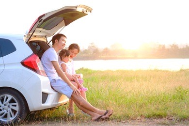 happy little girl with family sitting in the car.car insurance concept