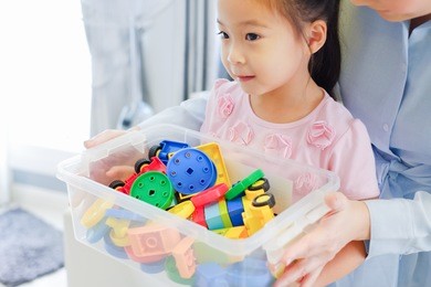 little cute asian girl playing plastic colorful toys