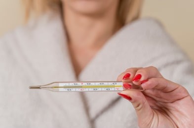 close up traditional thermometer for measuring body temperature in hand