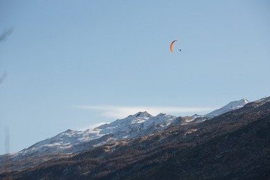paragliding over mountain ranges in queenstown, new zealand.