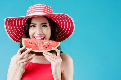 women wear dresses. she is eating watermelon. in the summer she feels refreshed
