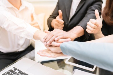 close-up group of business together as a team by overlapping hands to symbolize their cooperation in working successfull.