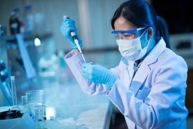 young female scientist using auto-pipette with flask in medical science laboratory. researcher concept.