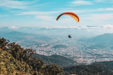 professional man and woman paragliding in blue sky in a sunny day 