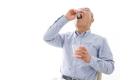 aged man taking a pill