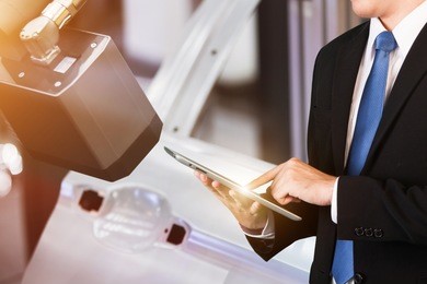 business owner use tablet with industry 4.0 technology for automotive industrial. robotic for automotive factory with digital optical sensor technology. digital optical 3d sensor with robotic arm.