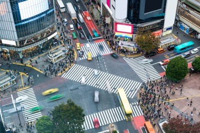 aerial view of pedestrians walking across with crowded traffic at shibuya crossing square