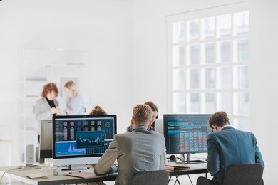 group of businessmen and businesswomen stock brokers working at office.