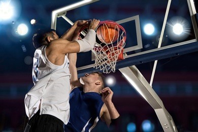 two basketball players in action in gym