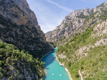 aerial photo of people have a rest in the gorge verdon on a catamarans, boats and paddles, lake cross, azure water of the river, the rocky coast with trees