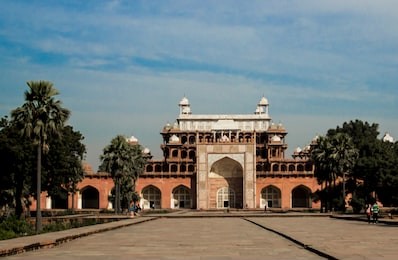akbar tomb at sikandra - a world heritage site. a red sandstone architecture gate with intricate mughal carvings.