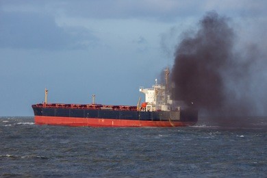 industrial cargo ship causing air pollution leaving the port of rotterdam.