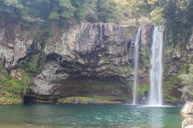 cheonjeyeon waterfall also known as the pond of god,originates from the ceiling of a cave, it is one of the largest tree major waterfall in jeju island, south korea.