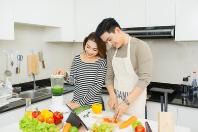 portrait of happy asian young couple cooking together in the kitchen at home.