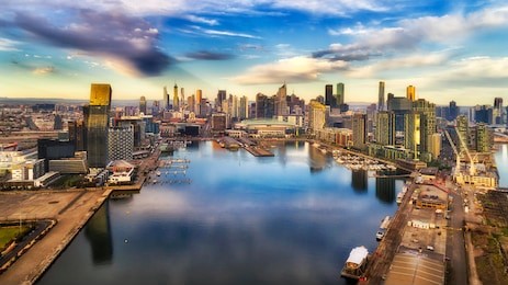 yarra river surrounded by melbourne suburb docklands in elevated aerial view facing city cbd waterfront and towers with marina and yachts.
