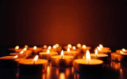 burning candles. shallow depth of field. many christmas candles burning at night. abstract candles background. many candle flames glowing on dark background. close-up. free space.