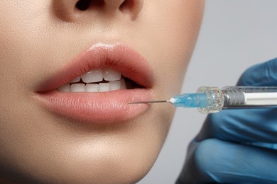 close up of female lips having hyaluronic acid lifting by syringe. beauty concept