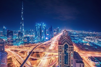 scenic nighttime skyline of a big modern city. dubai, uae. aerial view on famous highway interchange and skyscrapers.