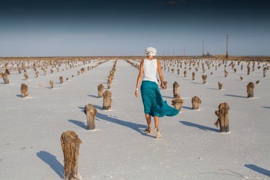 woman is walking along a salt lake, baskunchak, russia