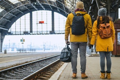 couple at railway station wiring for train. travel concept