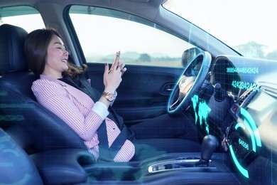 artificial intelligence (ai),internet of things concept,asian woman using a smartphone in an autonomous car, self driving vehicle.heads up technology icon display. automotive technology driverless car