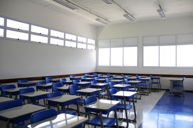 an empty lecture room / university classroom with blue chairs