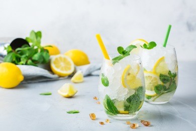 holidays and party, food and drink concept. cold alcohol mojito cocktail, long drink beverage, lemonade with lemon, mint and ice in a glass on a table