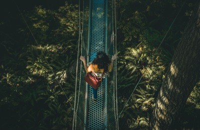 woman on suspension bridge in the jungle
