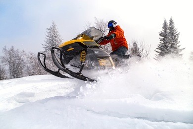athlete on a snowmobile moving in the winter forest in the mountains of the southern urals.
