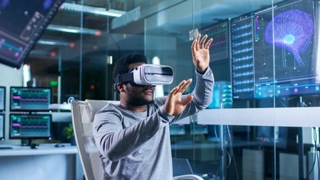 in laboratory scientist wearing virtual reality headset sitting in a chair interacts with monitors showing brain activity information. modern brain study/ neurological research center.