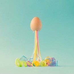 egg with party streamers. easter minimal concept.