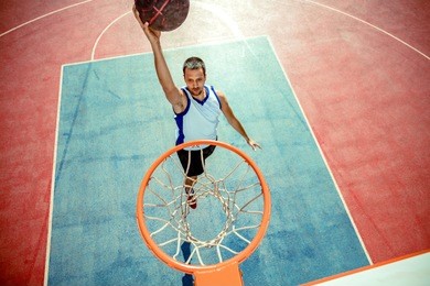 high angle view of basketball player dunking basketball in hoop