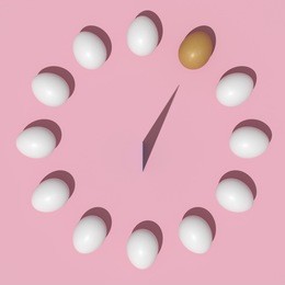 notable orange egg and white eggs shape of clock on pink background.minimal style