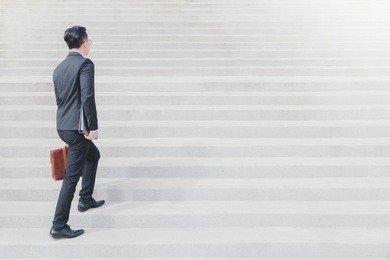 asian smart businessman walking up the stairs.concept of success business step.