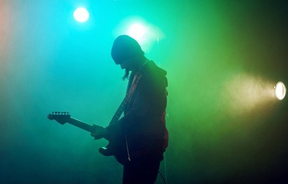 teenagers are playing rock. stage light, smoke.