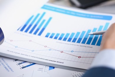 male hands hold documents laptop with financial