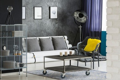 monochromatic sitting room interior with industrial, designer furniture, paper tubes couch and colorful elements