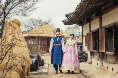 young korean couple in hanbok wolking in the park