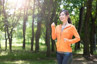 sporty asian woman relaxing in park