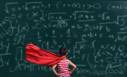 little child plays superhero. kid on the background of chalkboard background. education and success concept. asia kid learning art mathematics formula.
