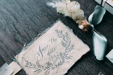 wedding rustic and graphic arts of beautiful calligraphy cards with flower and chiffon bobbins on wood background. beautiful wedding invitation. top view.