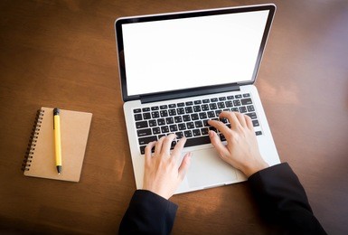 top view, hand typing laptop on desk work with pen on notebook.
