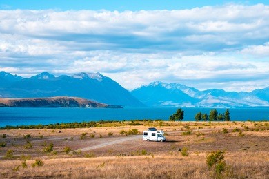 beautiful scene of campervan, car, the yellow grassland mt cook and lake tekapo before sunset.